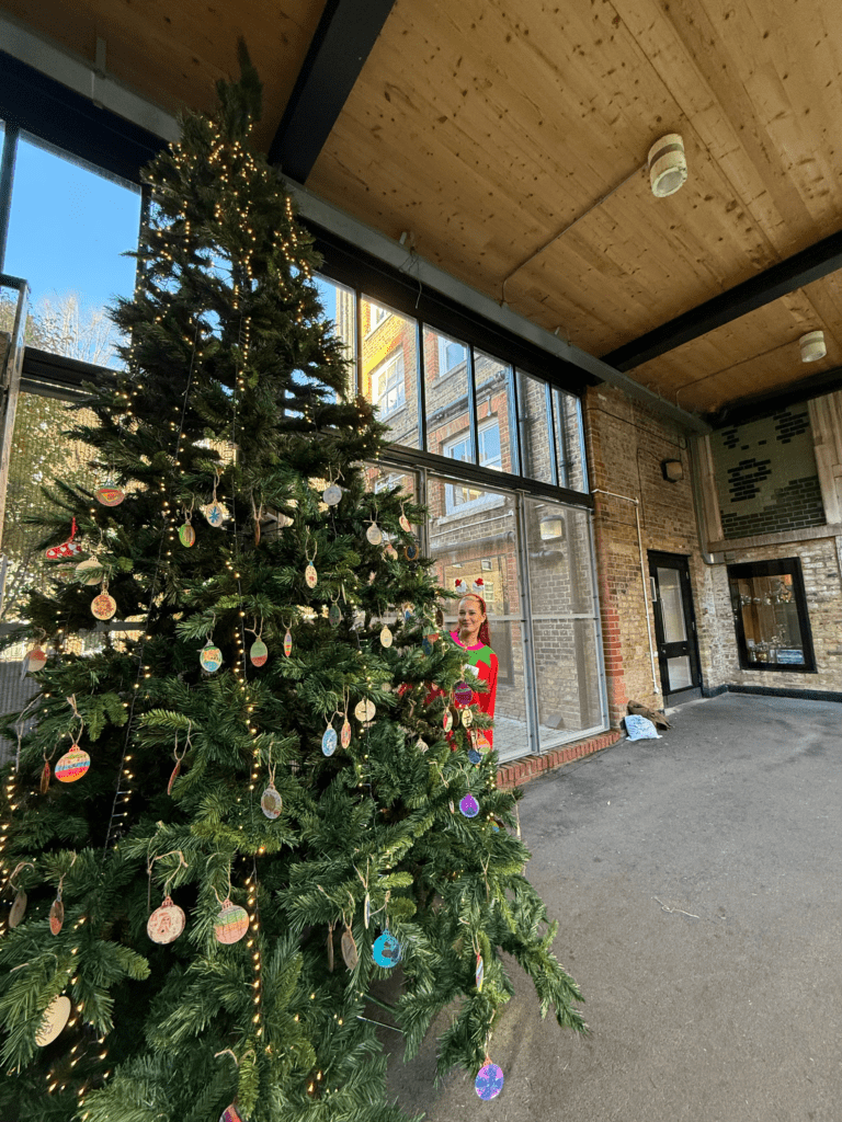 Image of tall Christmas tree decorated with lights and baubles